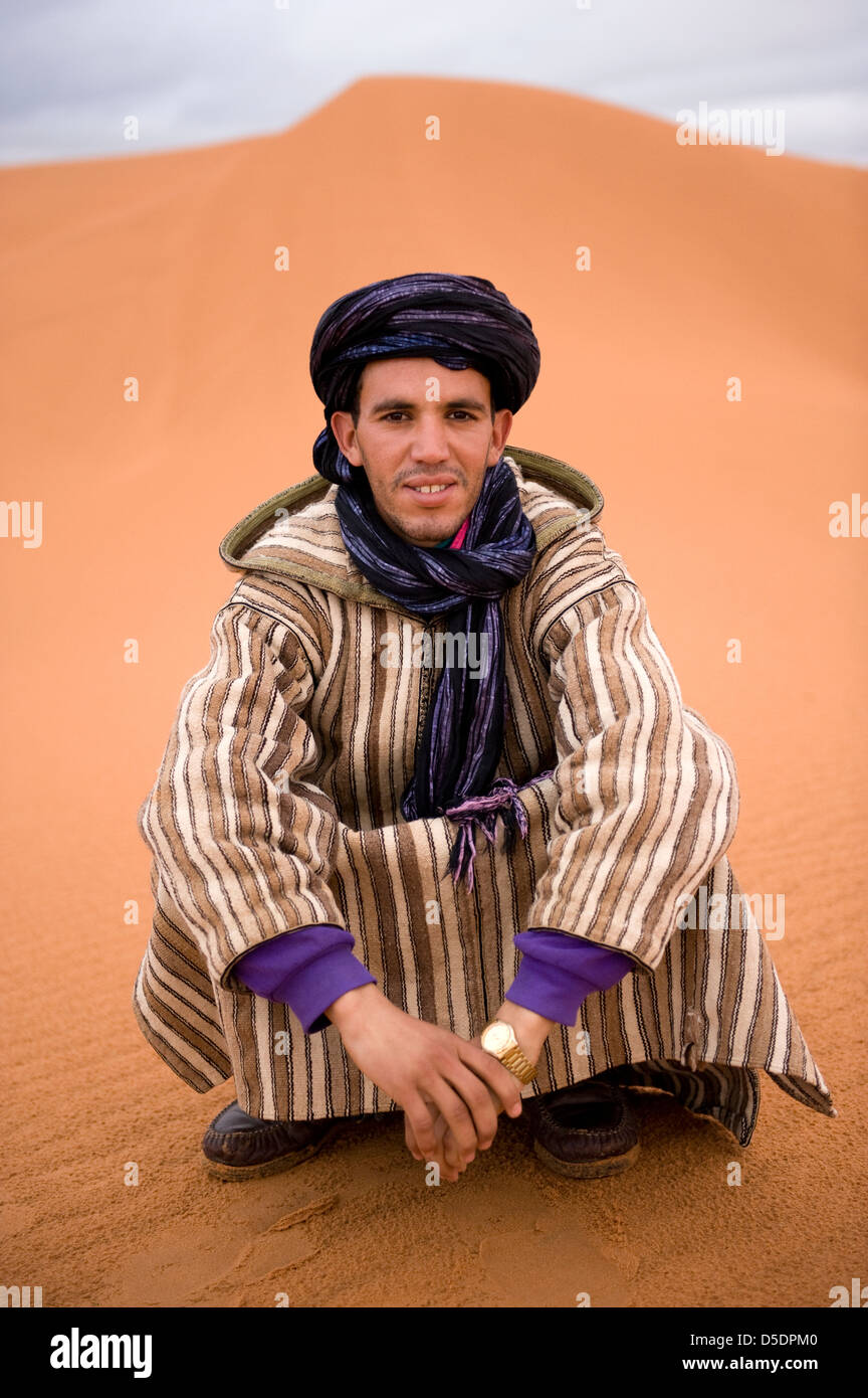 The guide wears a traditional robe, called a Gandora or djellabas, and head scarf Stock Photo