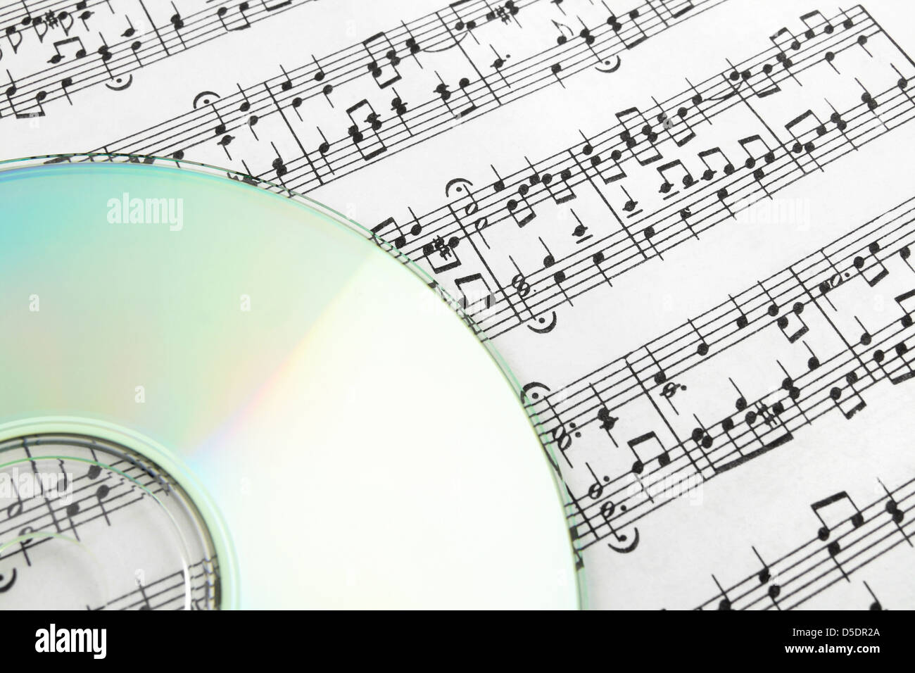 CD on sheet music. Digital music concept. Stock Photo