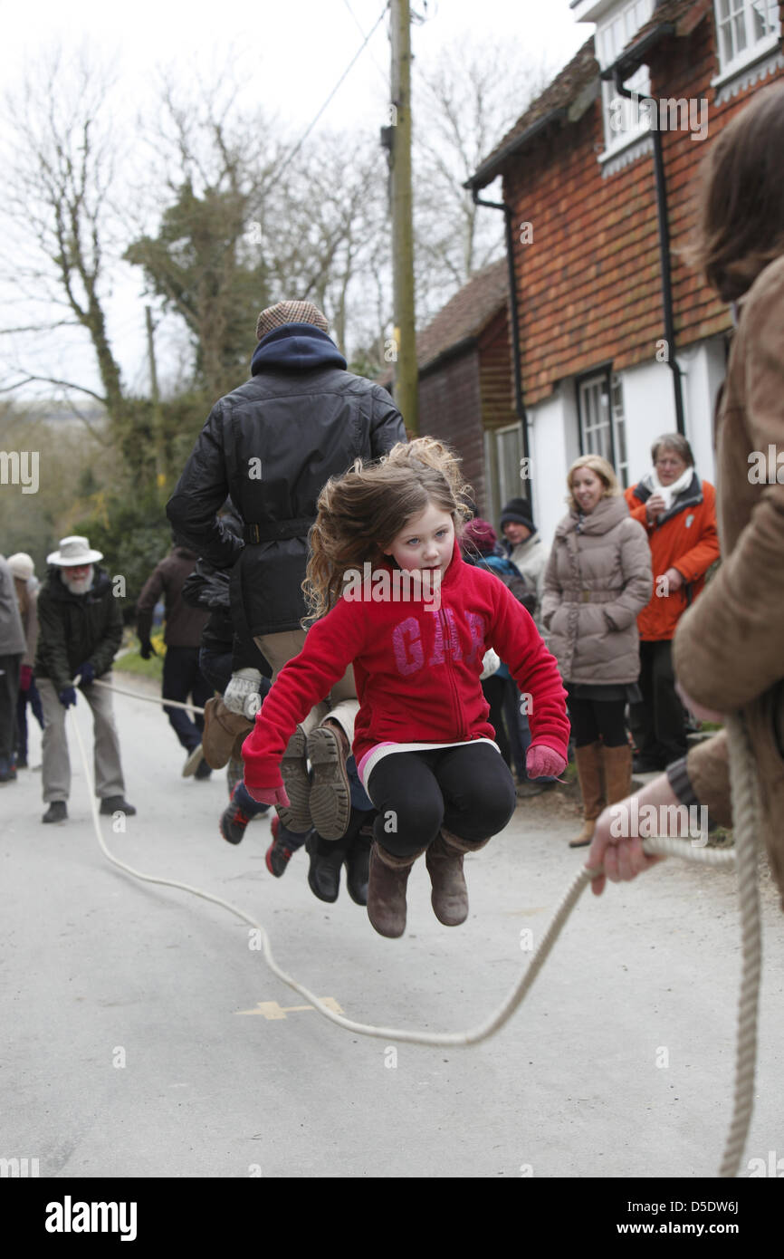 Locals of all ages take part in the custom of long rope skipping outside the pub in Alciston, East Sussex on Good Friday. Stock Photo