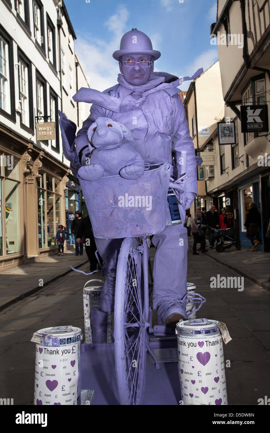 The Purple man, a man standing still. A street performer living statue at the special annual Easter Crafts and Food Fayre held  in St Sampson's Square and Parliament Street where street vendors exhibit their wares filling the streets with the taste and smells of good Yorkshire fare. The City of York, Yorkshire, UK Good Friday 29th March, 2013. Stock Photo