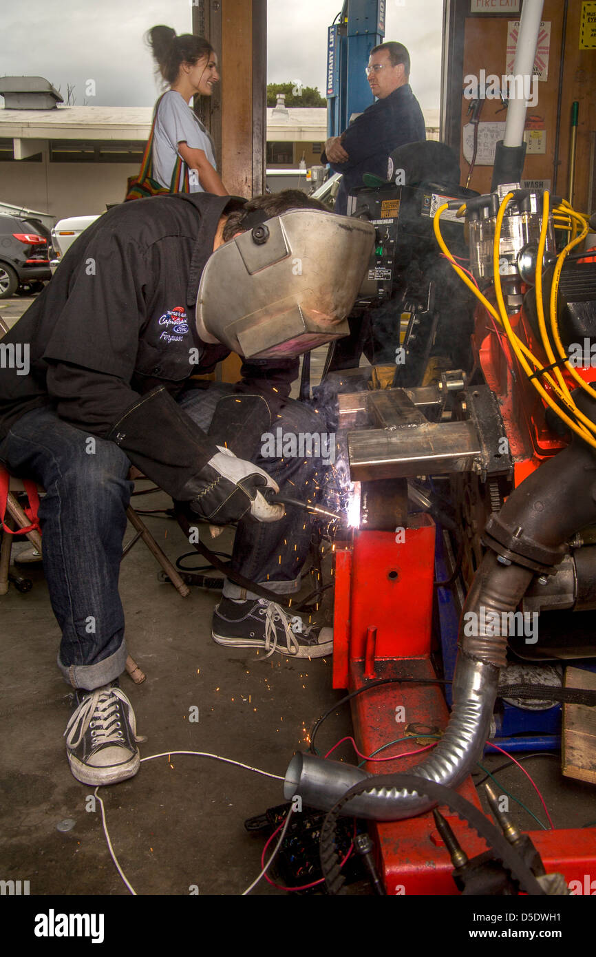 A teen boy prepares to arc weld an engine support in a high school auto shop class in San Clemente, CA. Stock Photo