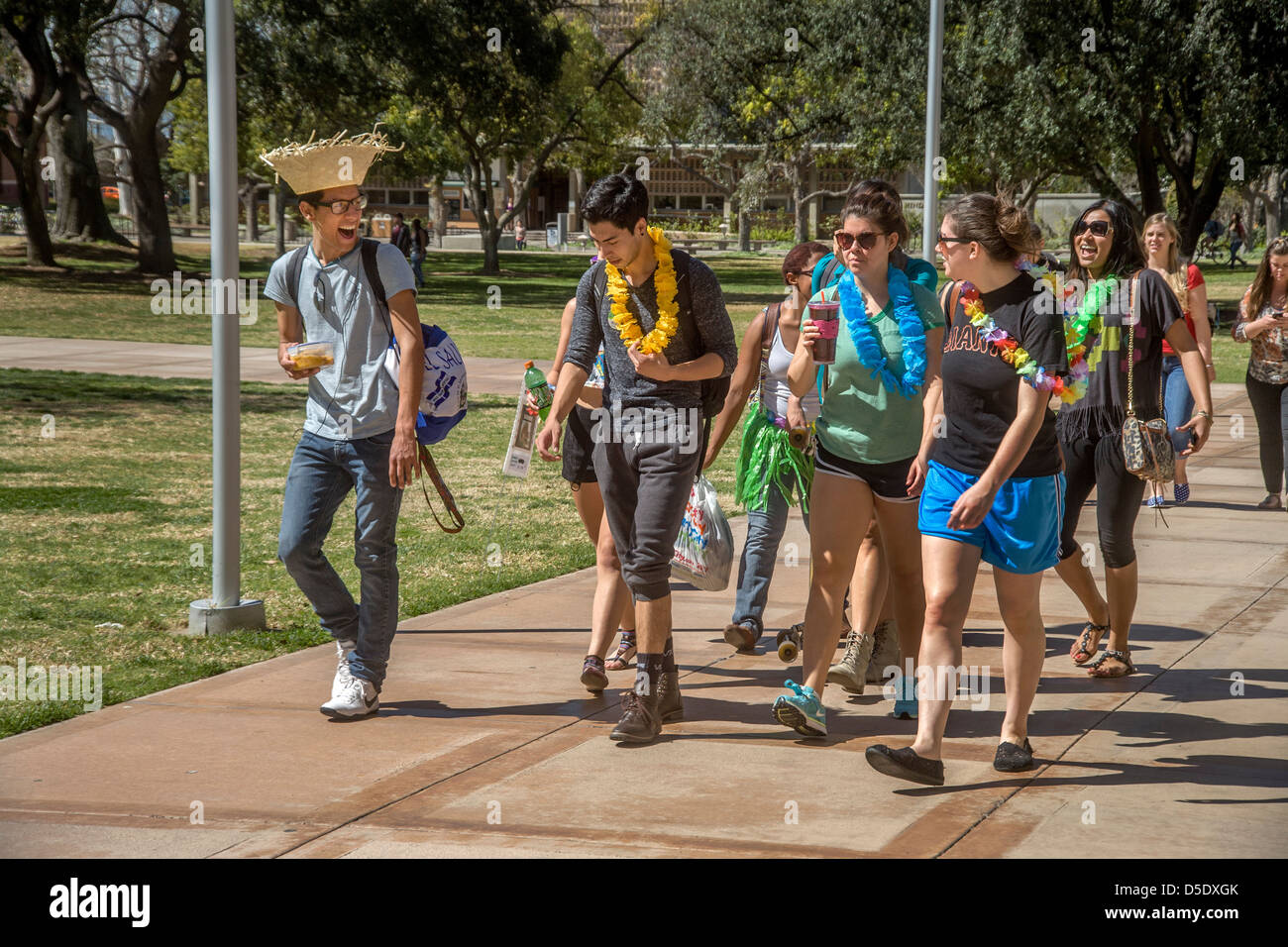 Multiethnic college students in Hawaiian hats and leis walk through the campus of the University of California at Riverside. Stock Photo