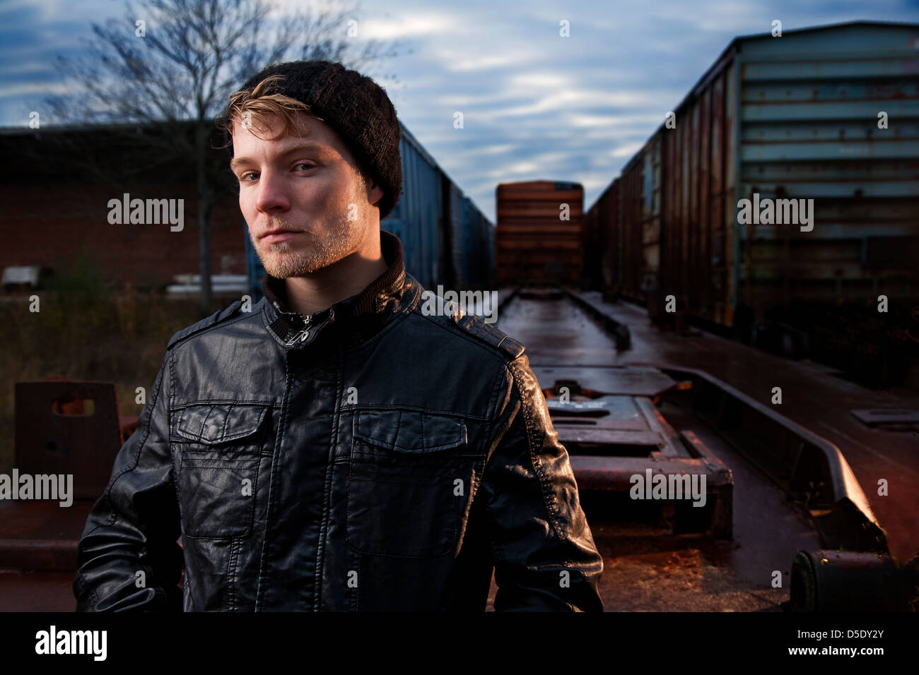 Man in cap and jacket in rail road yard Stock Photo