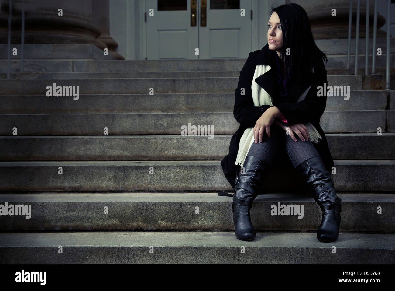 Woman sitting alone on steps waiting Stock Photo