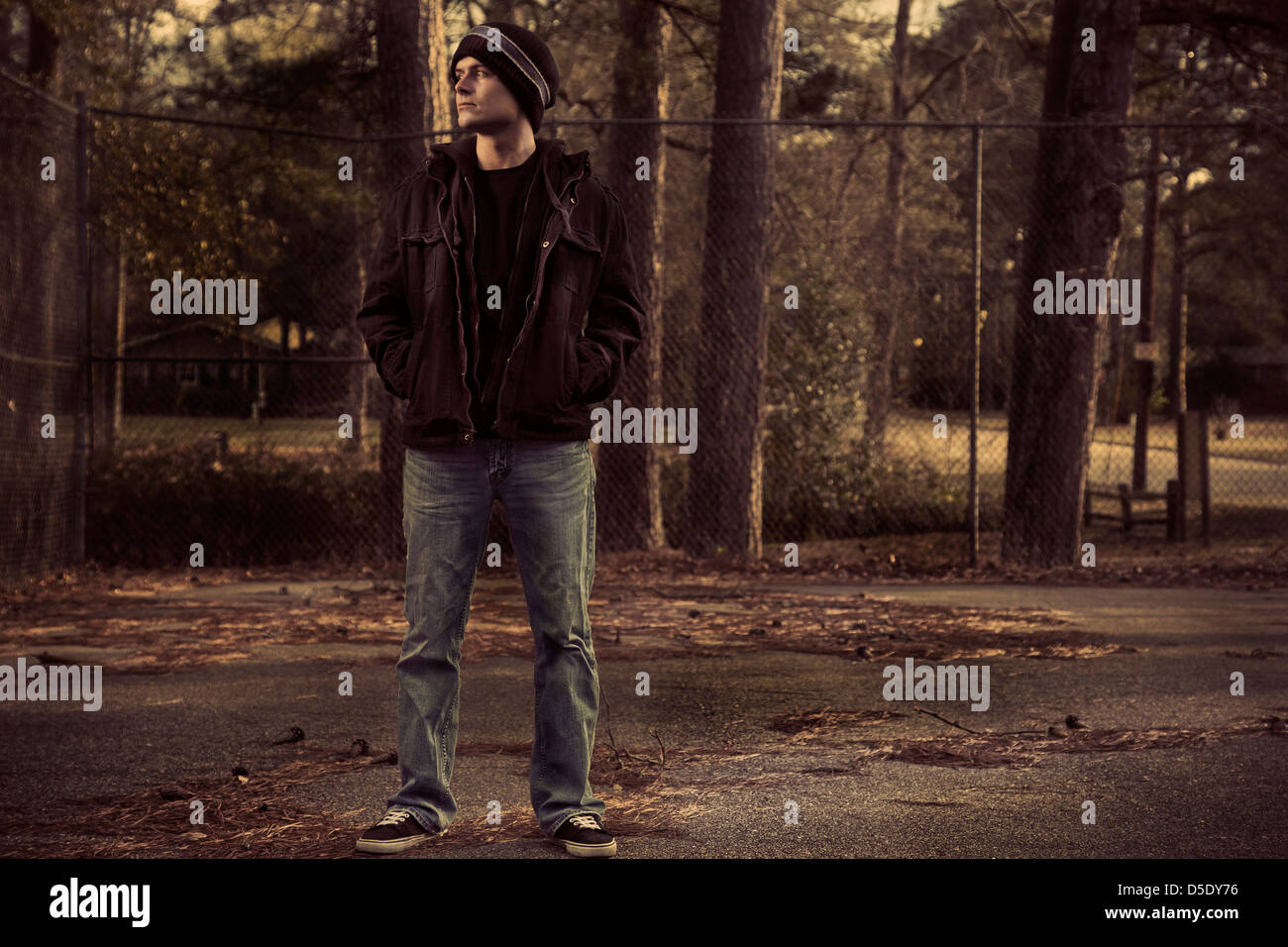 Man standing in old basketball court in sitting sun Stock Photo