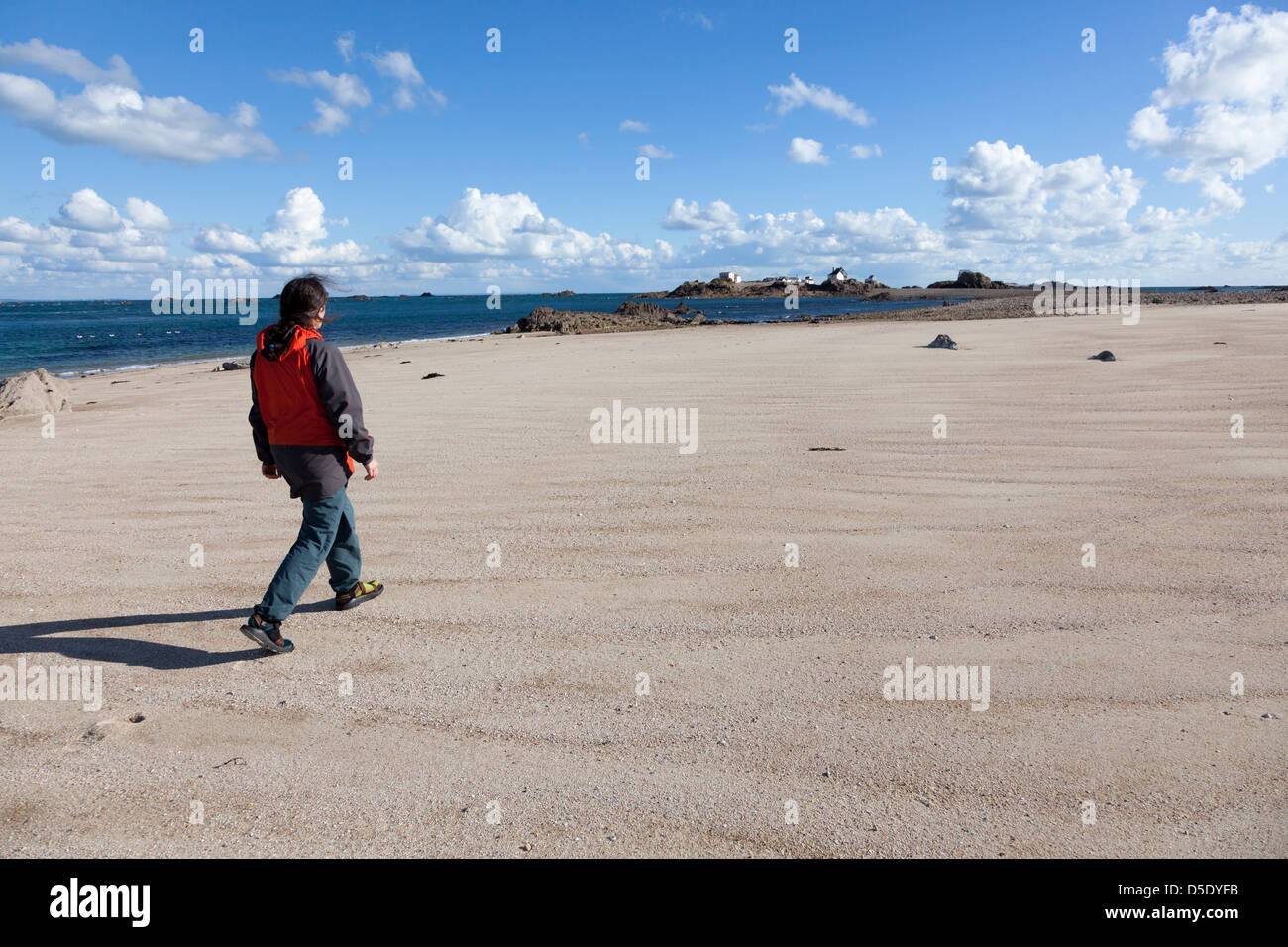 Woman walking on sandy beach, Ecrehous island off Jersey, Channel Islands, UK Stock Photo
