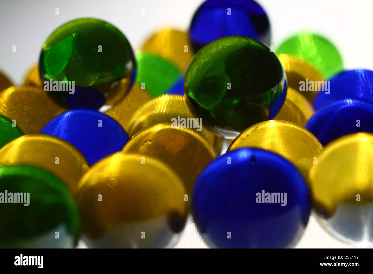 Blue, yellow and green marbles on a white background Stock Photo Alamy