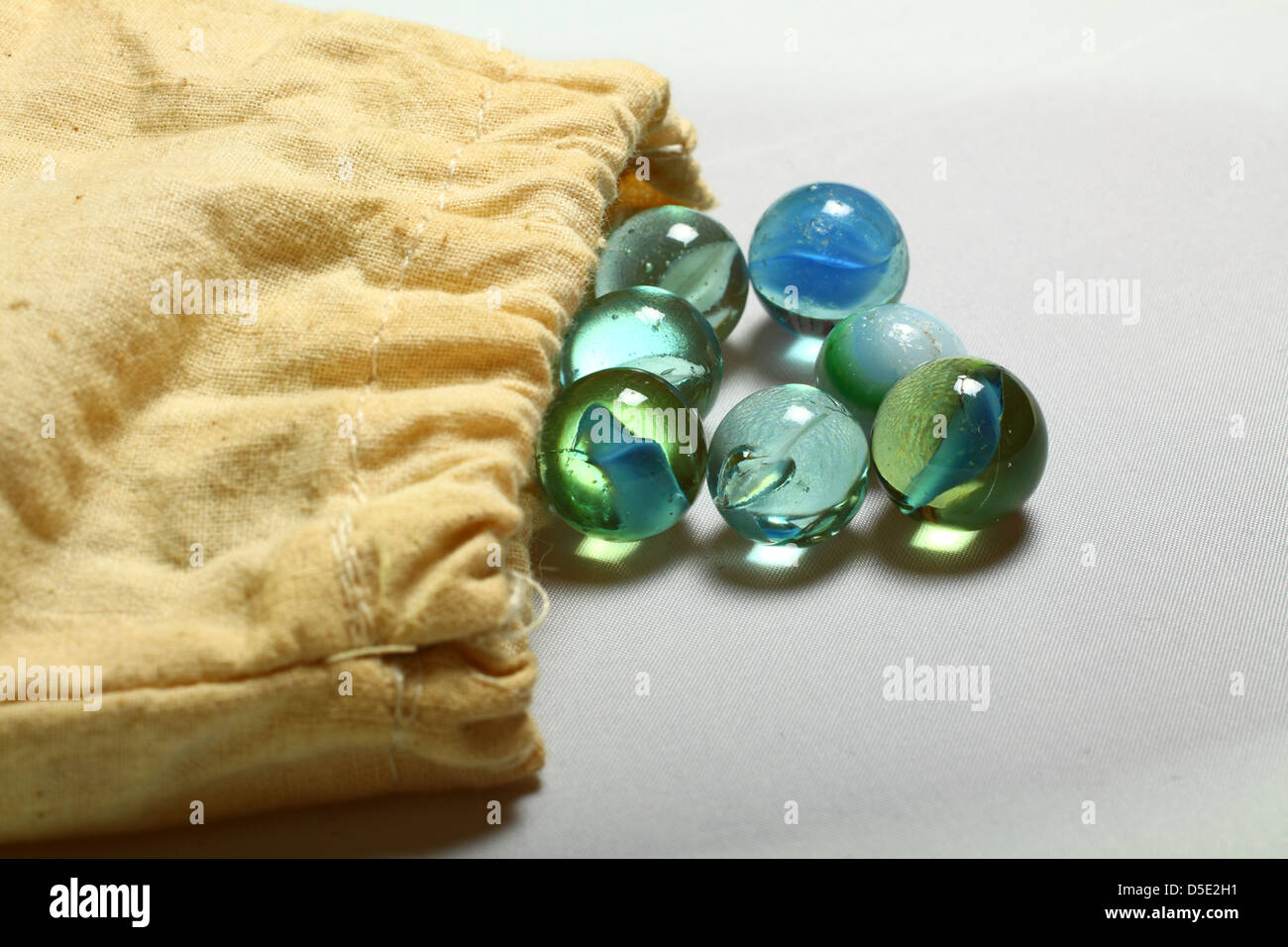 Marbles spilling out of drawstring bag Stock Photo Alamy