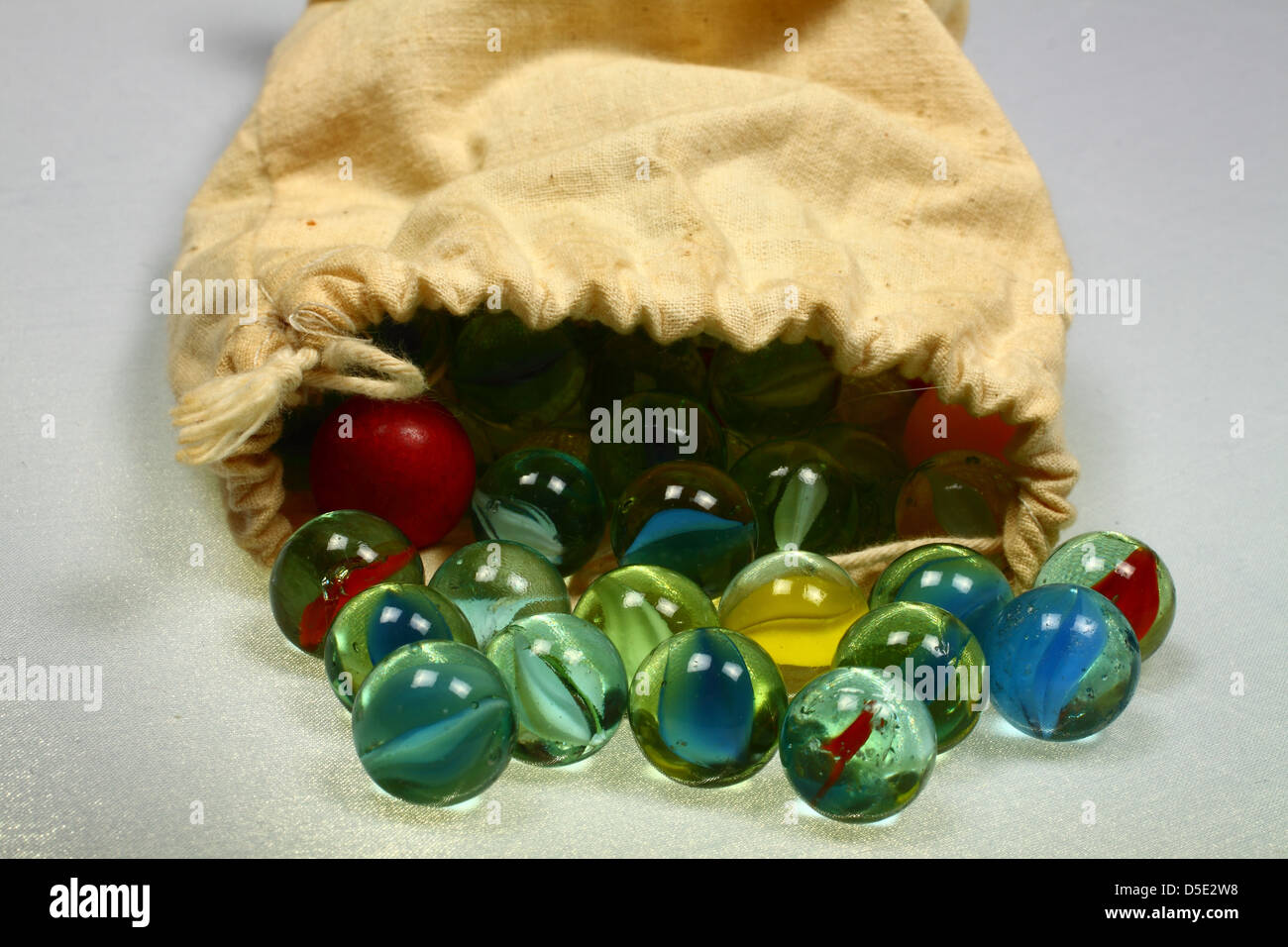 Marbles spilling out of drawstring bag Stock Photo Alamy