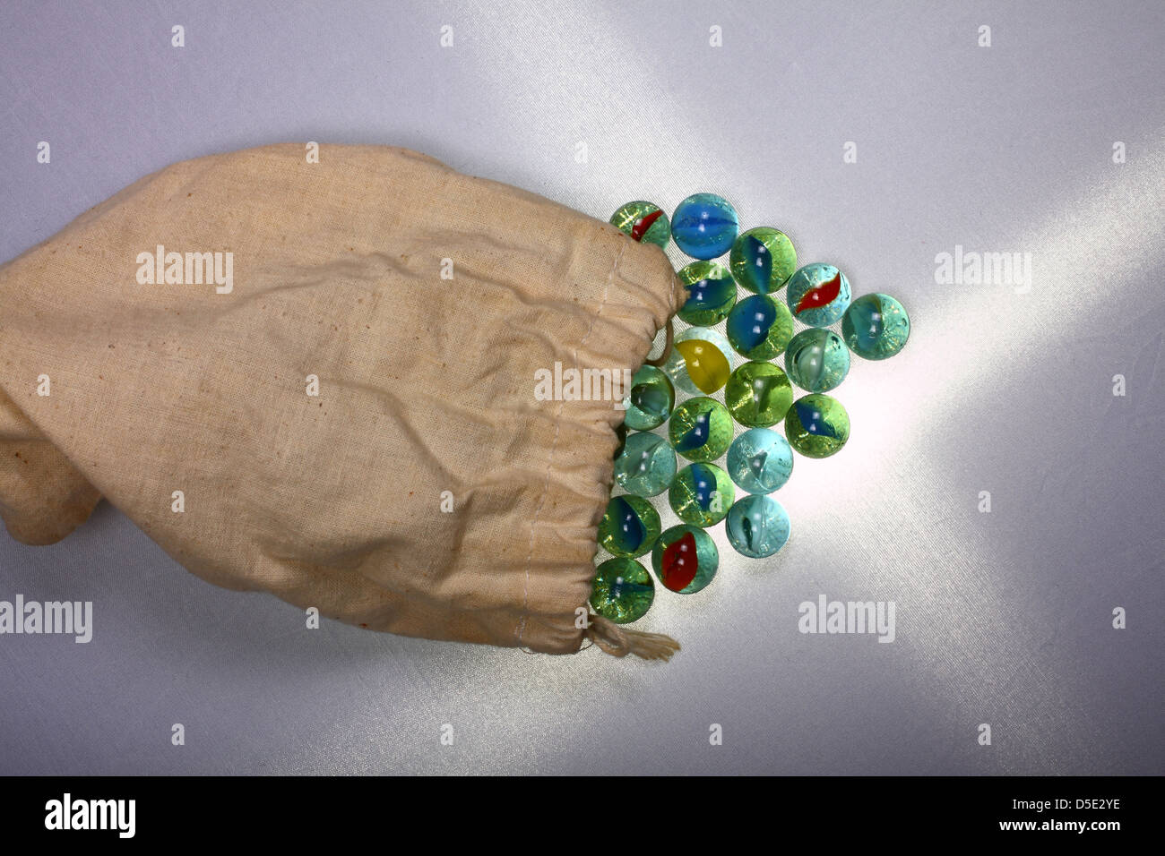 Marbles spilling out of drawstring bag Stock Photo Alamy