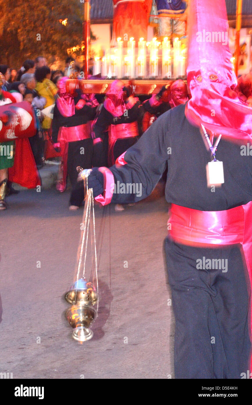 Man handling an incense dispenser during a catholic procession for