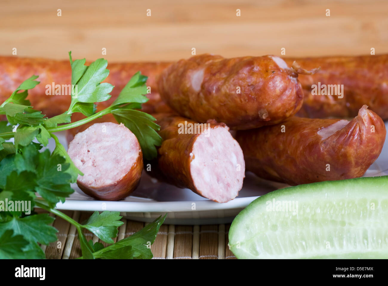 piece of the pork sausage with parsley and cucumber Stock Photo