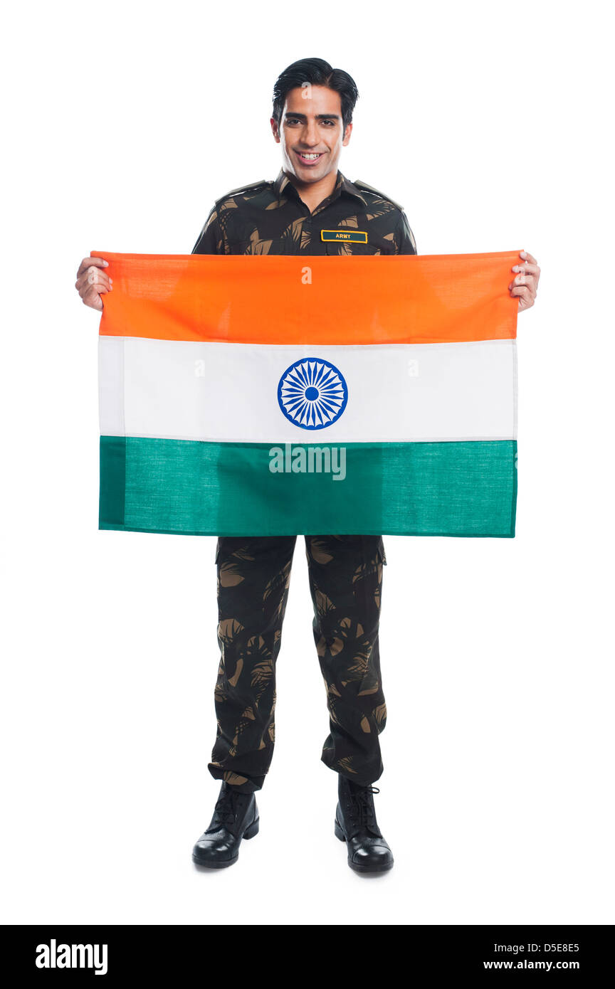 Portrait of an army soldier holding Indian flag and smiling Stock Photo