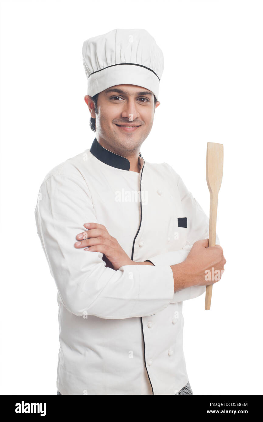 Portrait of a male chef holding a spatula and smiling Stock Photo