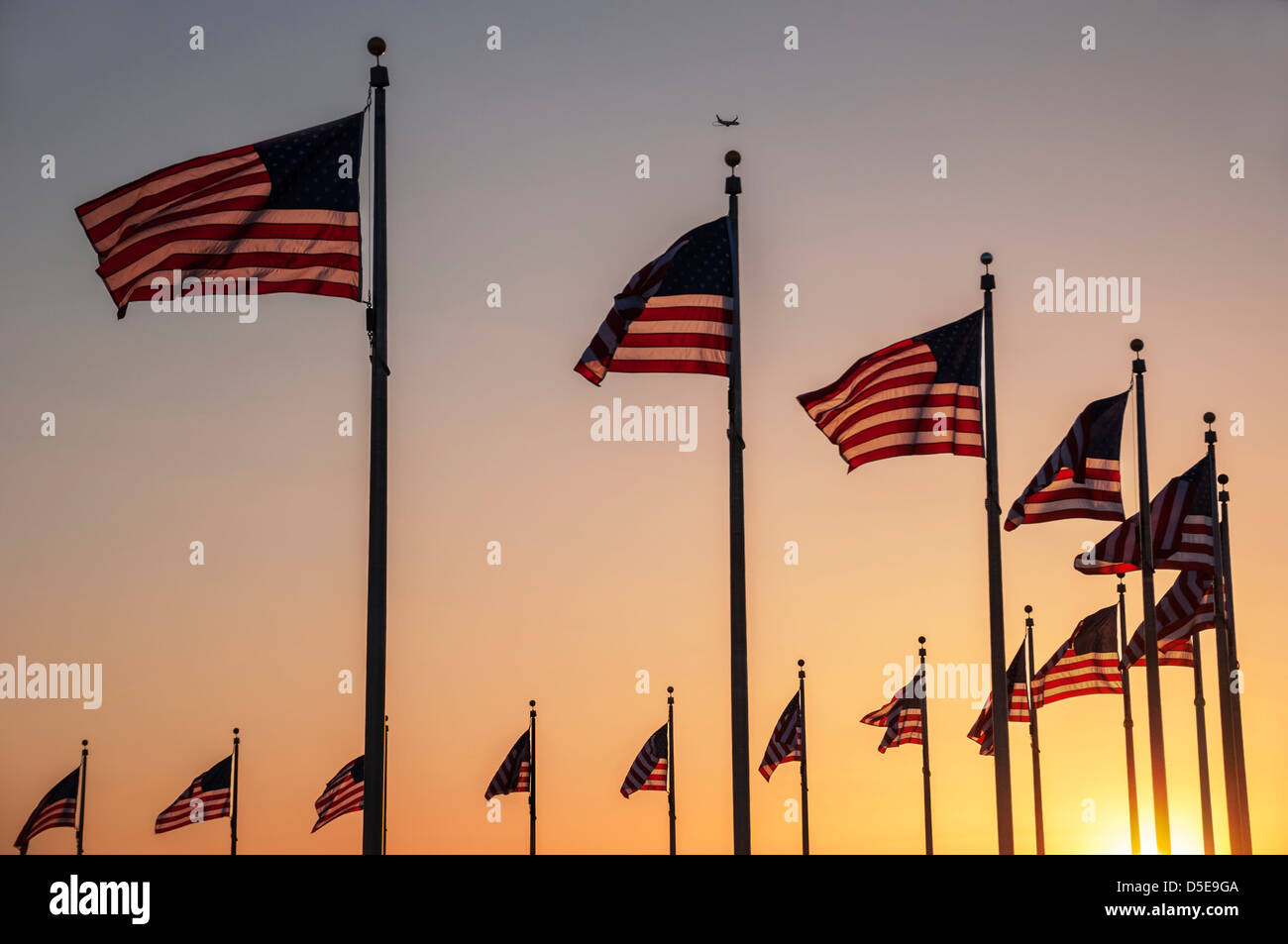 Flags around the base of the Washington Monument at sunset Stock Photo