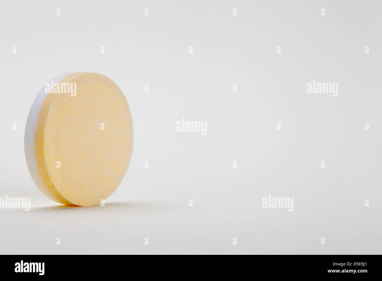 yellow and white single tablet on white background with empty space for text Stock Photo