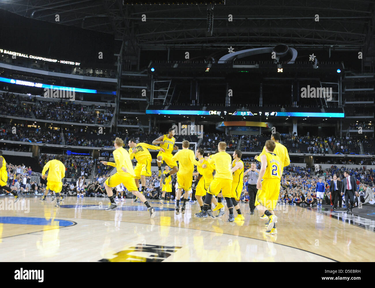 March 29, 2013: The Michigan players celebrate on the court at the end of regulation time after the NCAA Tournament South region game between the University of Michigan Wolverines and the University of Kansas Jayhawks at Cowboys Stadium in Arlington, TX Michigan defeated Kansas 87-85 Stock Photo