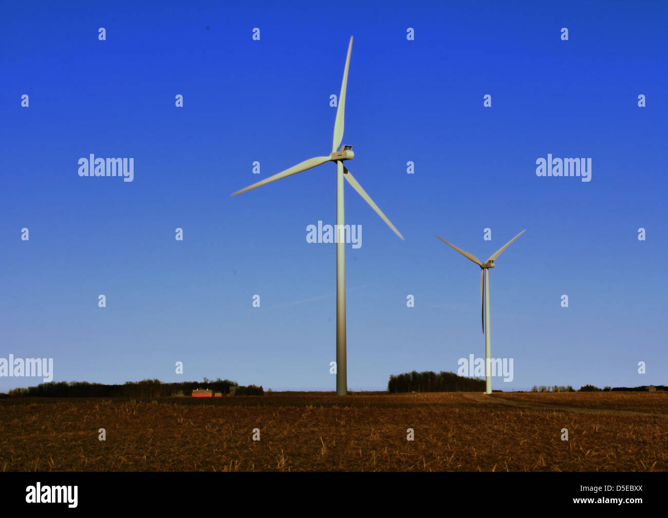 Wind turbine reaching into a gorgeous blue sky with agricultural fields ...