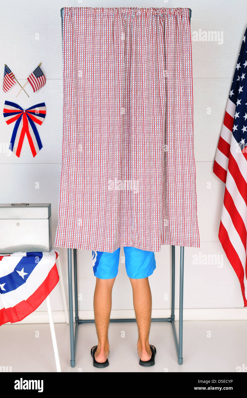 A Young male Voter inside a Voting Booth at his local polling place. Stock Photo