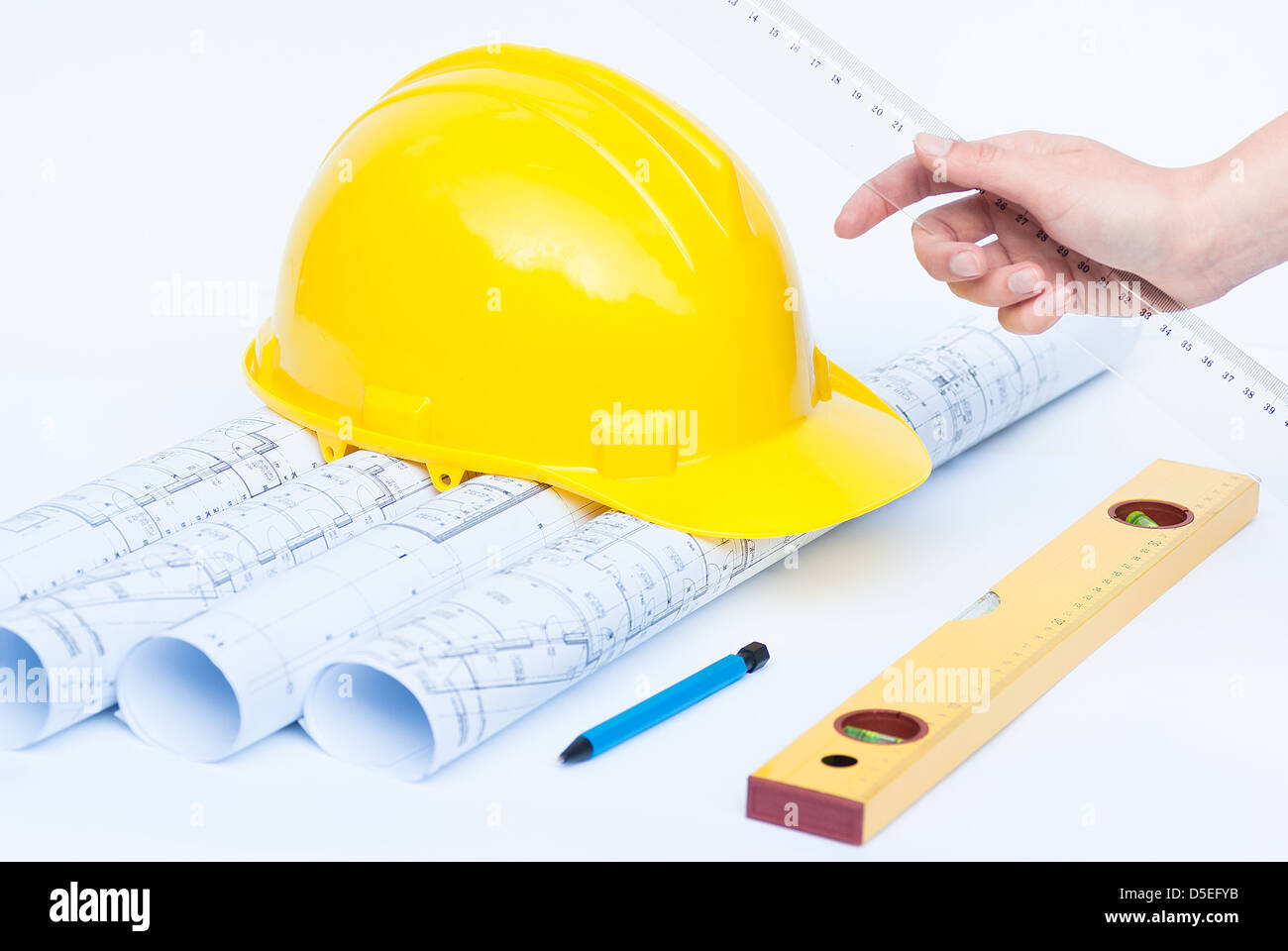 Construction rolls and plans and yellow helmet Stock Photo - Alamy
