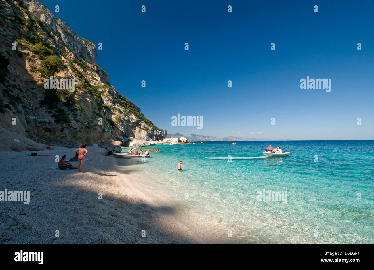 Tourists on holiday enjoy the nice sea of Cala Mariolu beach, Baunei, Orosei gulf, Ogliastra province,Sardinia, Italy Stock Photo