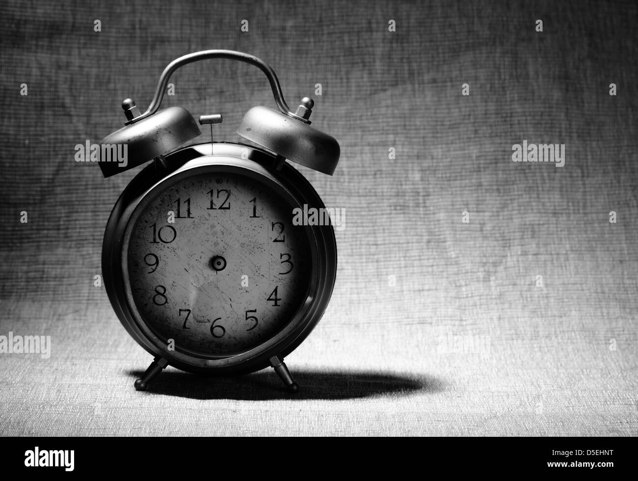 close-up of old broken alarm clock without clock hands on textile background with copy space for your text Stock Photo