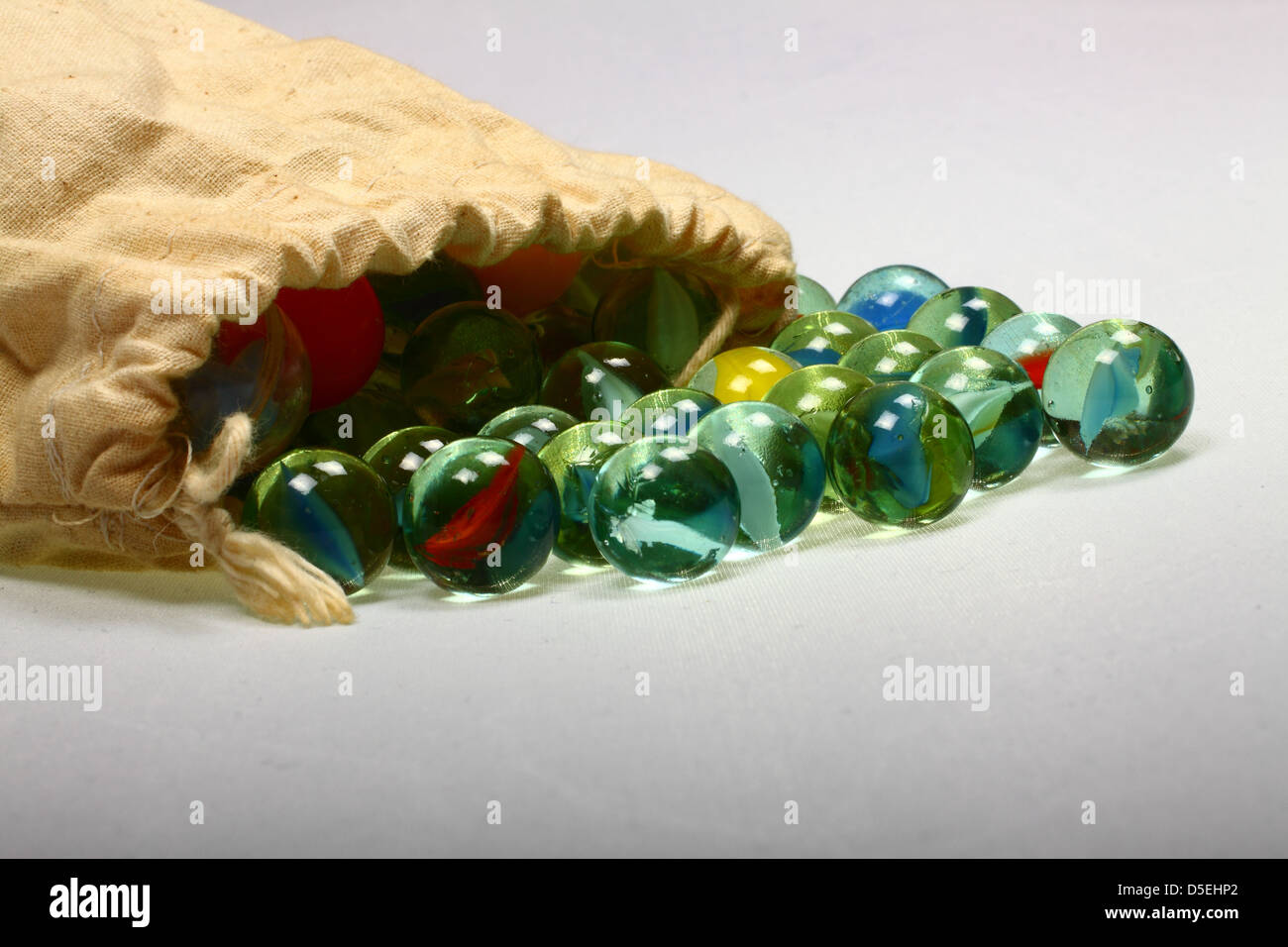 Marbles spilling out of drawstring bag Stock Photo Alamy