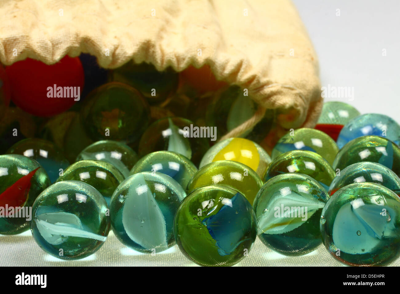 Marbles spilling out of drawstring bag Stock Photo Alamy