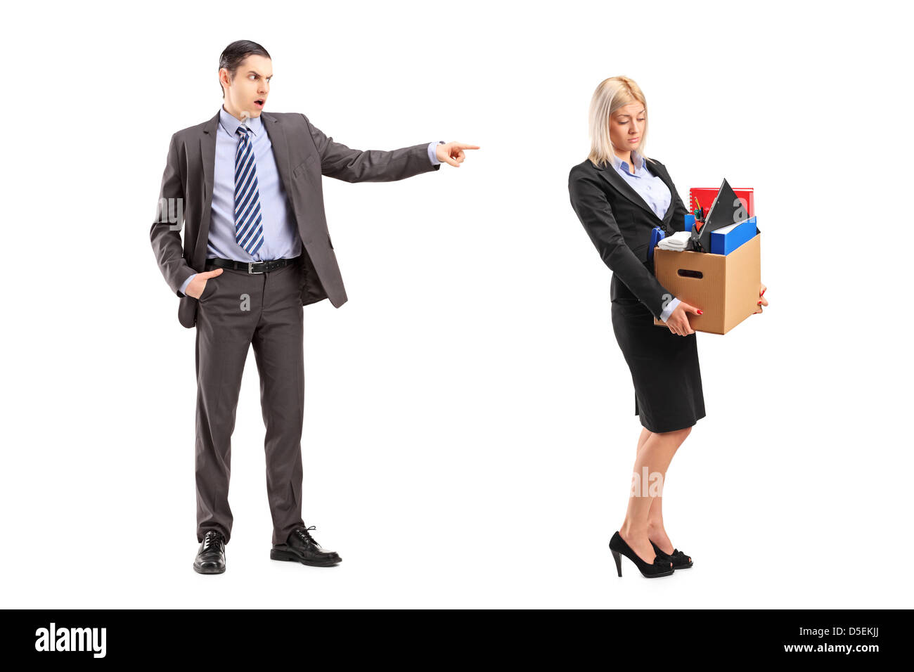 Full length portrait of an angry boss firing a woman with a box of her personal items isolated on white background Stock Photo