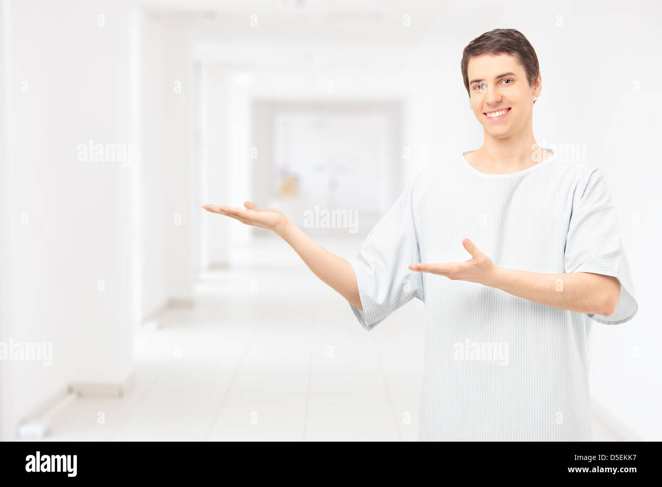 Male patient wearing hospital gown and gesturing with hands in a