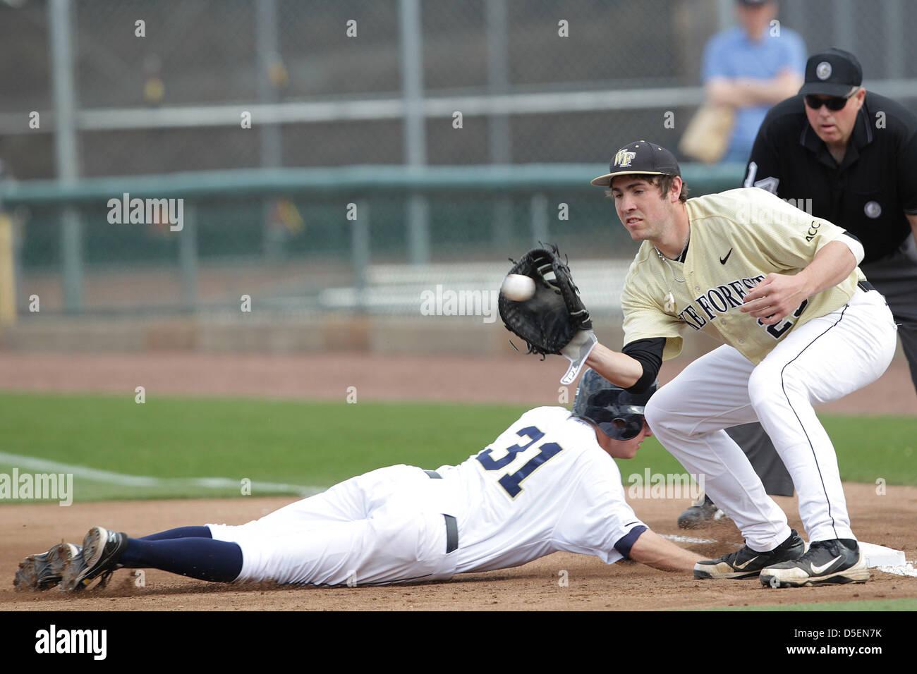 Atlanta, Georgia, USA. 30th March, 2013. The Georgia Tech Yellow Jackets wrapped up a 3-game series with a double header against the the Wake Forest Demon Deacons at Russ Chandler Stadium in Atlanta Georgia. Georgia Tech 3rd baseman Sam Dove (31) dives back to 1st before the throw to Matt Conway (25). The Yellow Jackets dropped the second game to Wake Forest 8-6. Stock Photo