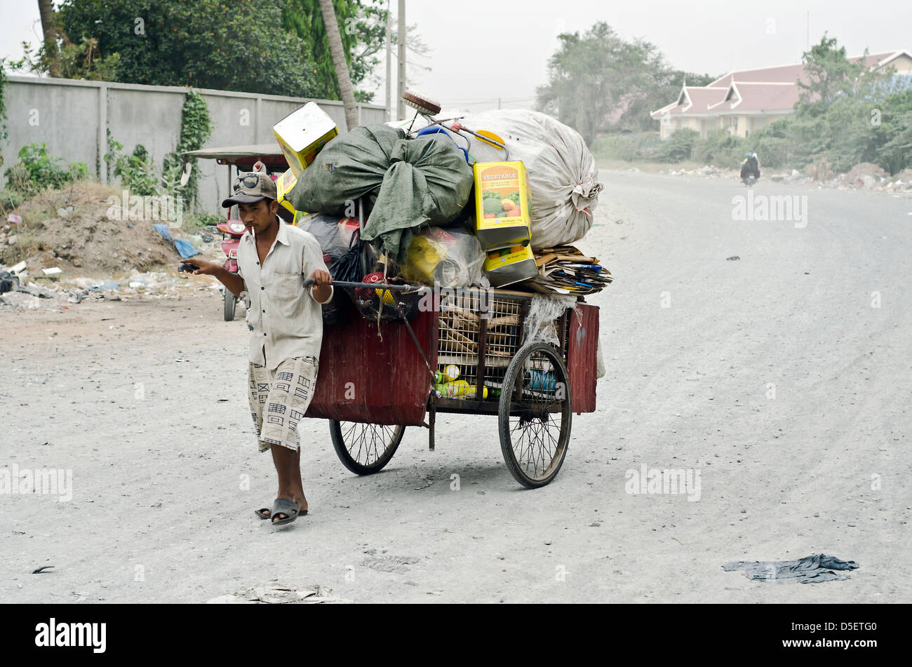 Man pulling cart of materials for  recycling,Phnom Penh,Cambodia Stock Photo