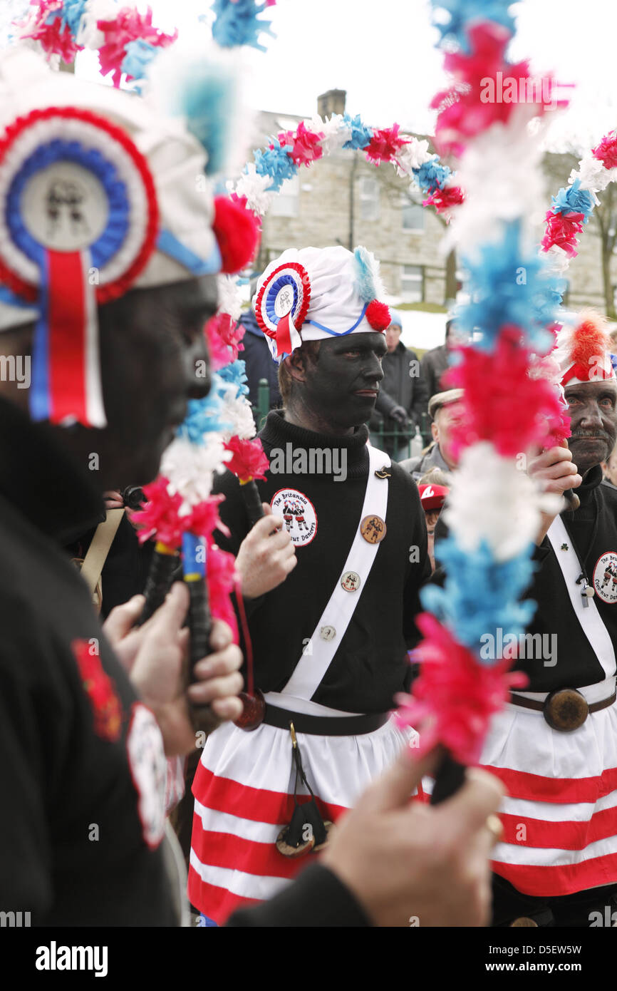 Britannia Coco-nut Dancers of Bacup, accompanied by Stacksteads Silver Band, dance their way around Bacup, UK on Easter Saturday Stock Photo