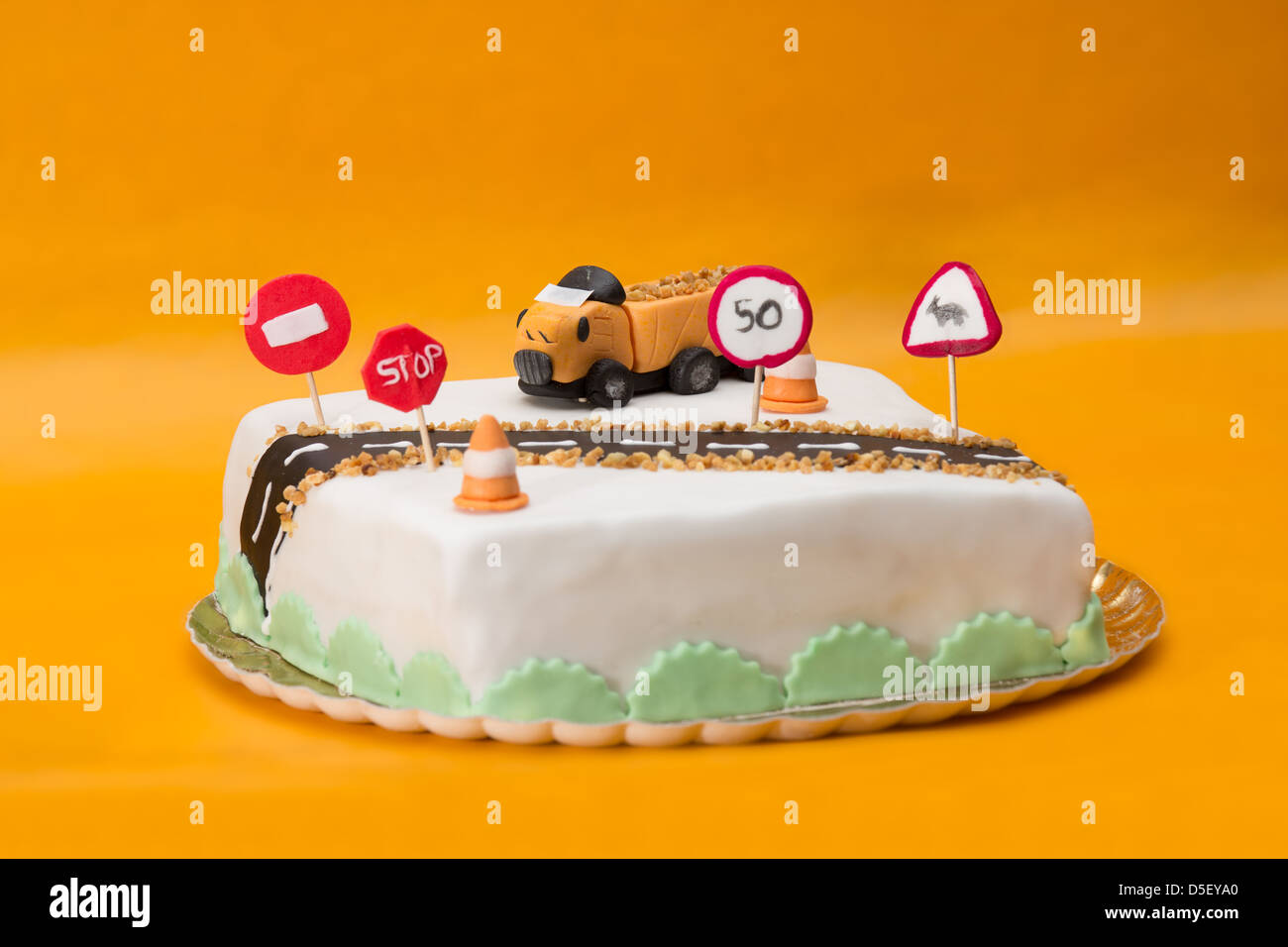 Two tier tall cake with fondant truck and road decoration on orange  background Stock Photo - Alamy
