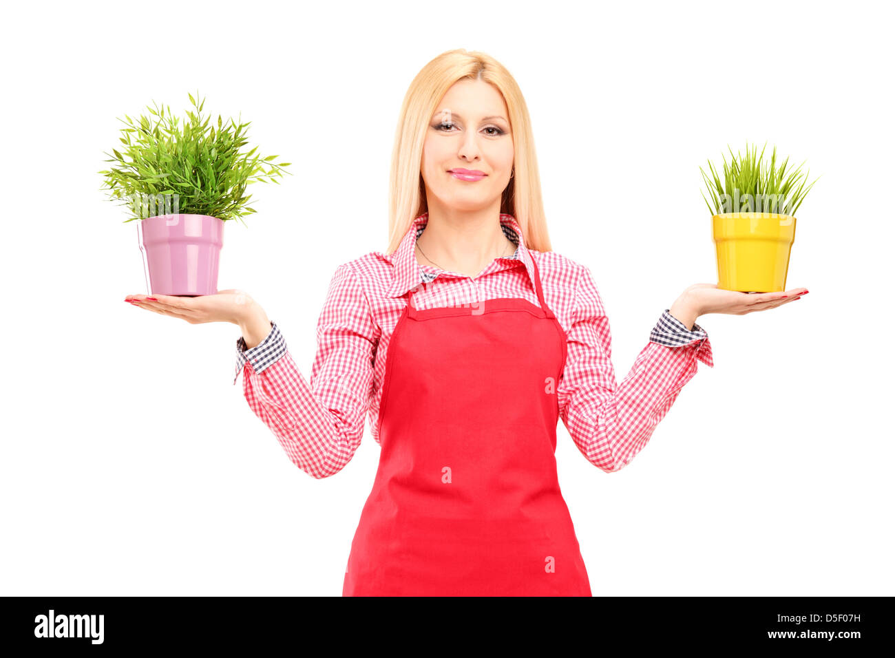 A blond female gardener holding two potted plants isolated on white ...