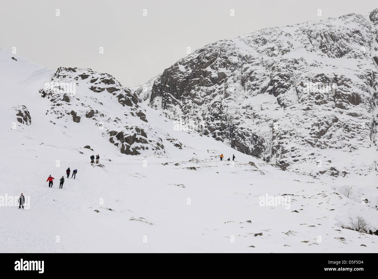 Walkers ascending the path by Ruddy Gill towards Great End in winter in the English Lake District Stock Photo