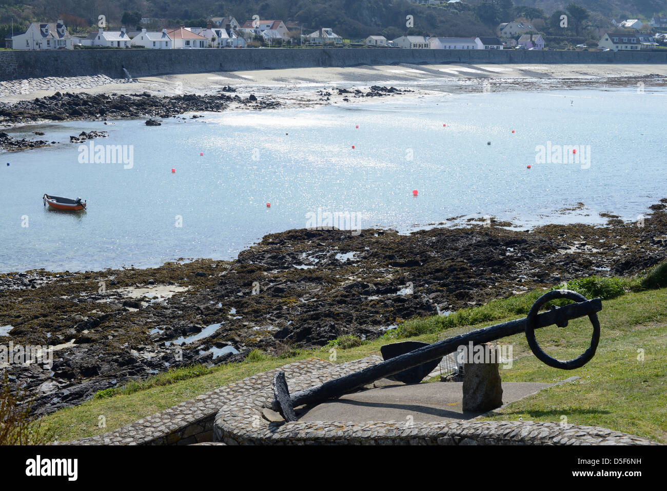 Anchor and view across Rocquaine Bay in Guernsey from The Shipwreck Museum Stock Photo