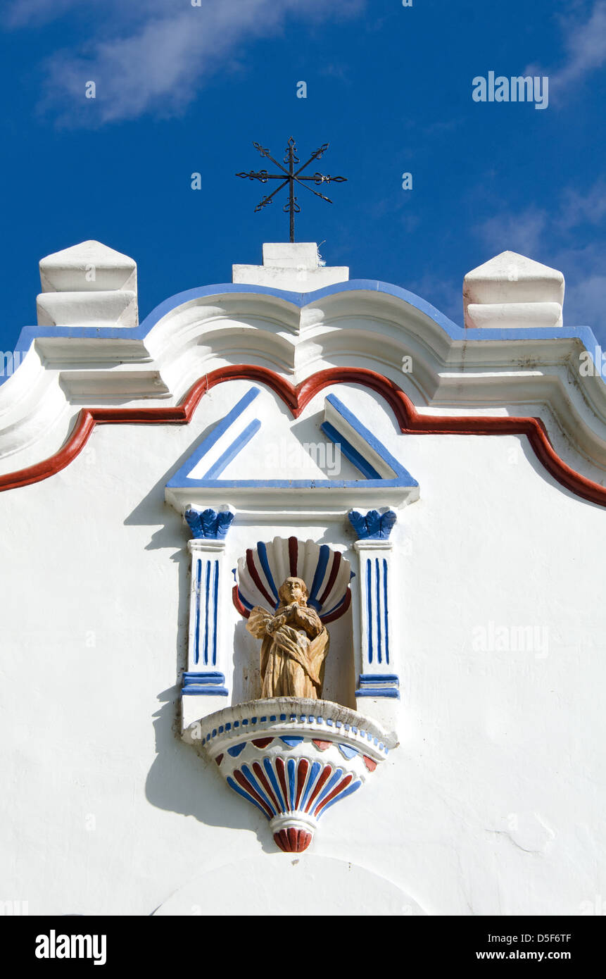 A statue of the Virgin Mary in a niche on the gaily painted facade of Santa Maria de la Asuncion in Tule, Mexico. Stock Photo