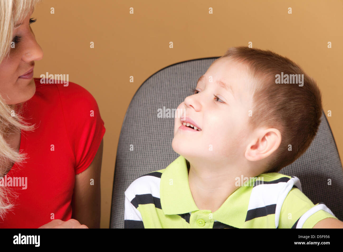 Portrait of a happy mature mother with child 6 years boy brown background Stock Photo