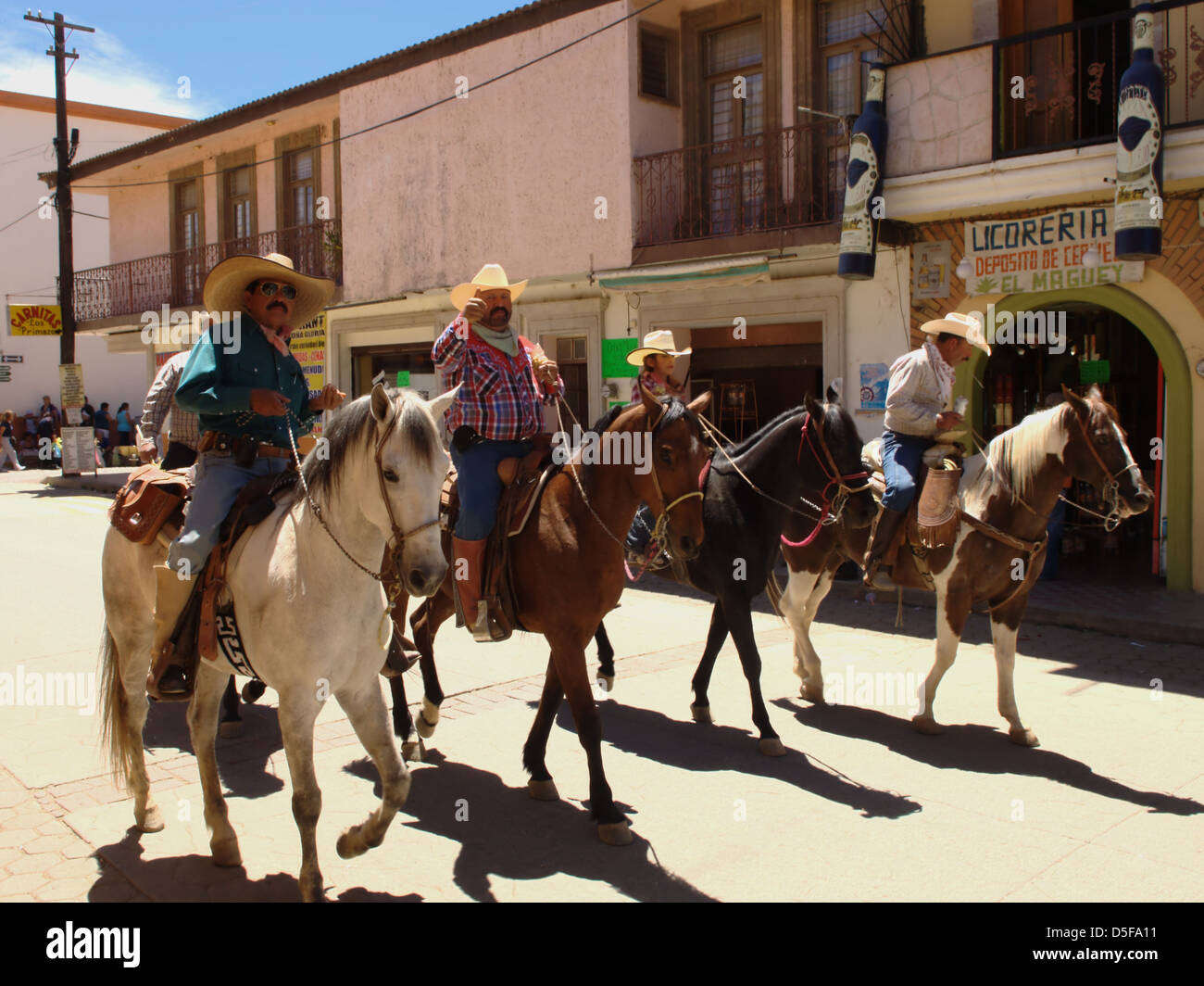 vaqueros riding through Talpa de Allende, Mexico. Stock Photo