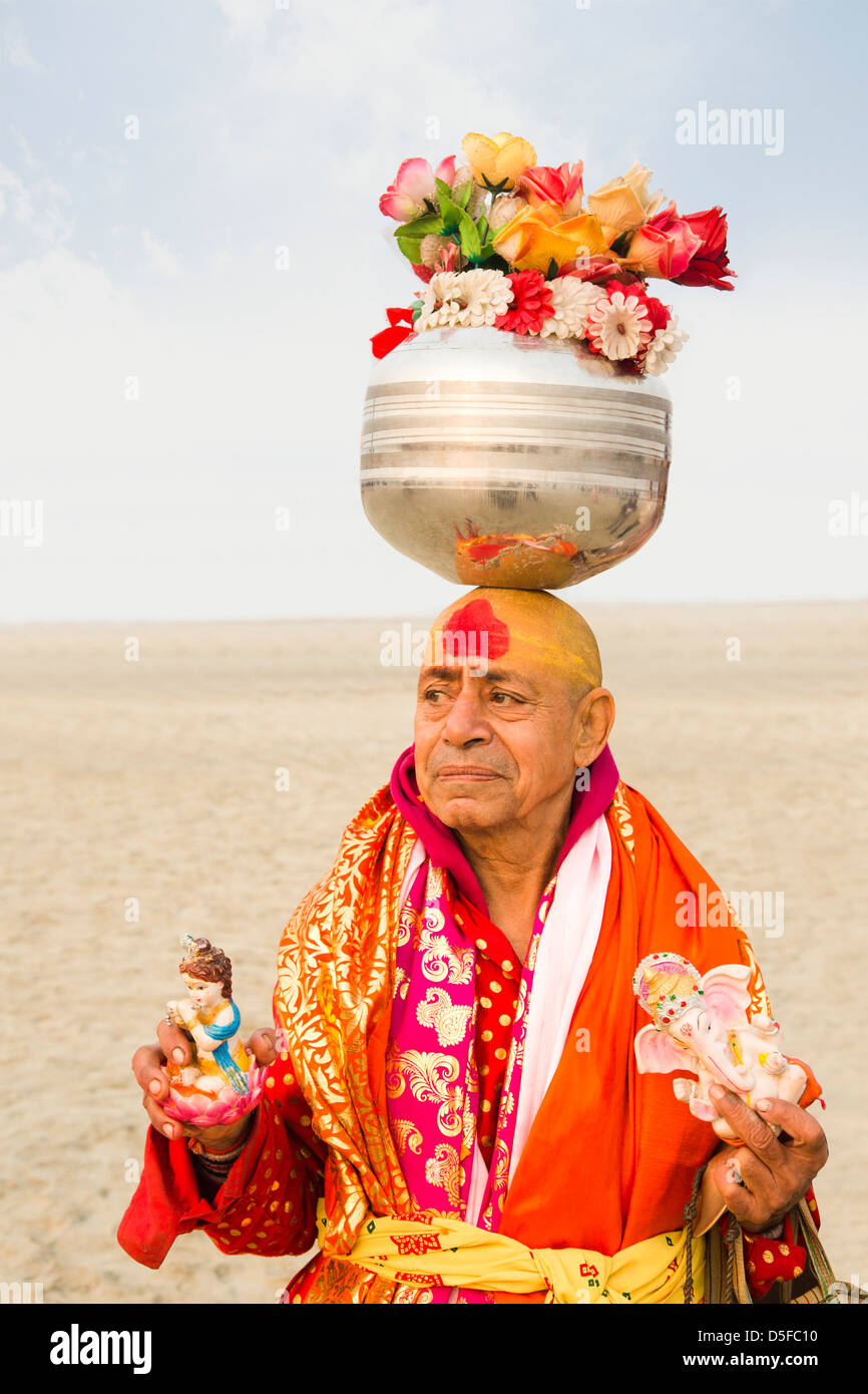 Sadhu balancing stainless steel pot containing artificial flowers on