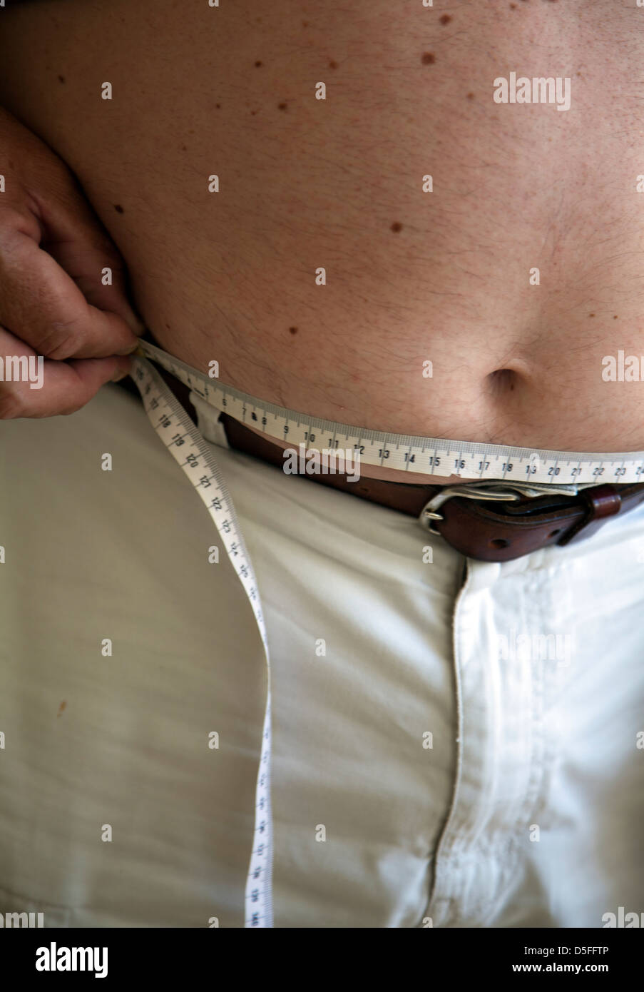 Man with Measuring Tape Round Waist Stock Photo