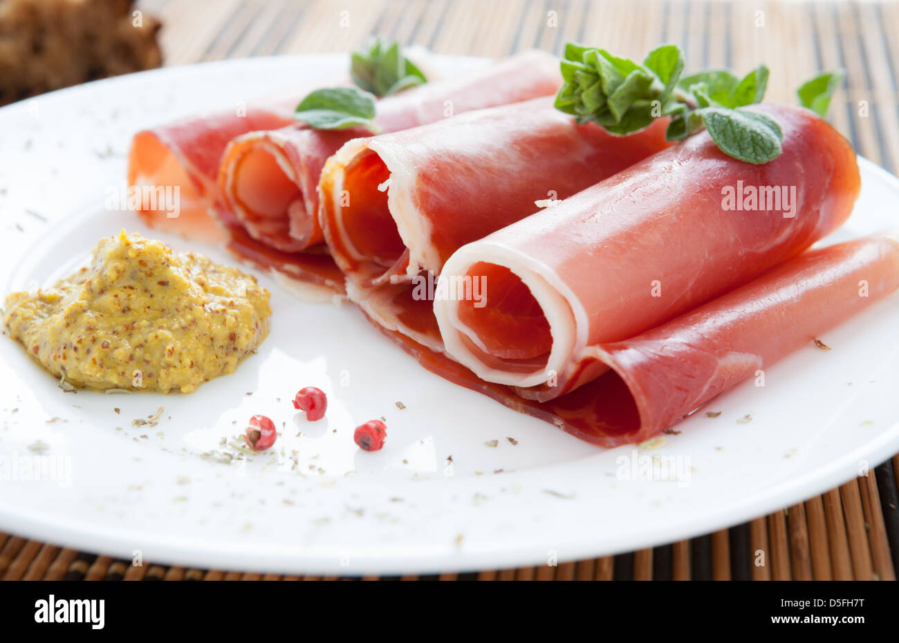 folded tubes ham and mustard on a plate, closeup Stock Photo - Alamy
