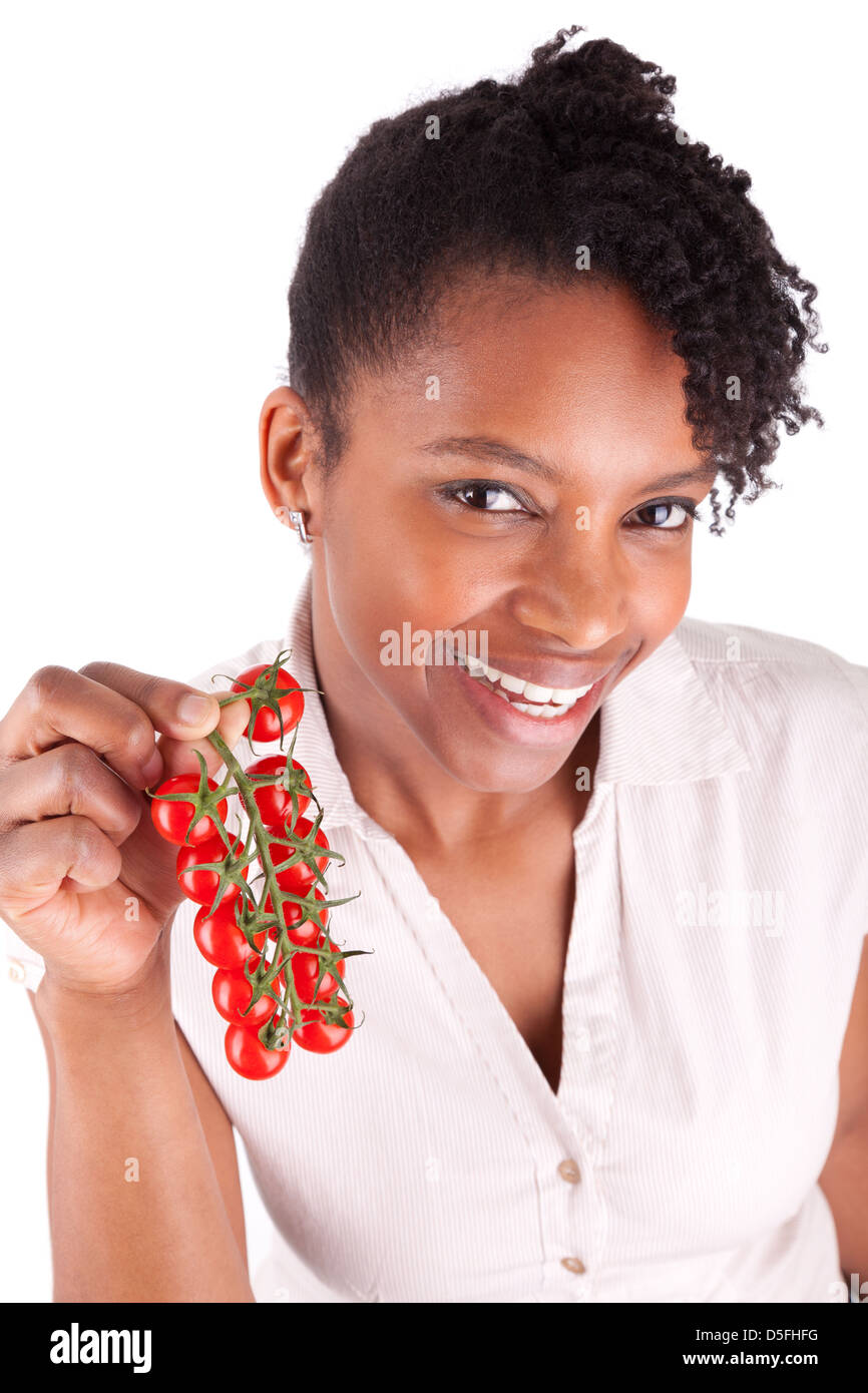 Young happy black / african american woman holding tomatoes, isolated on white background Stock Photo