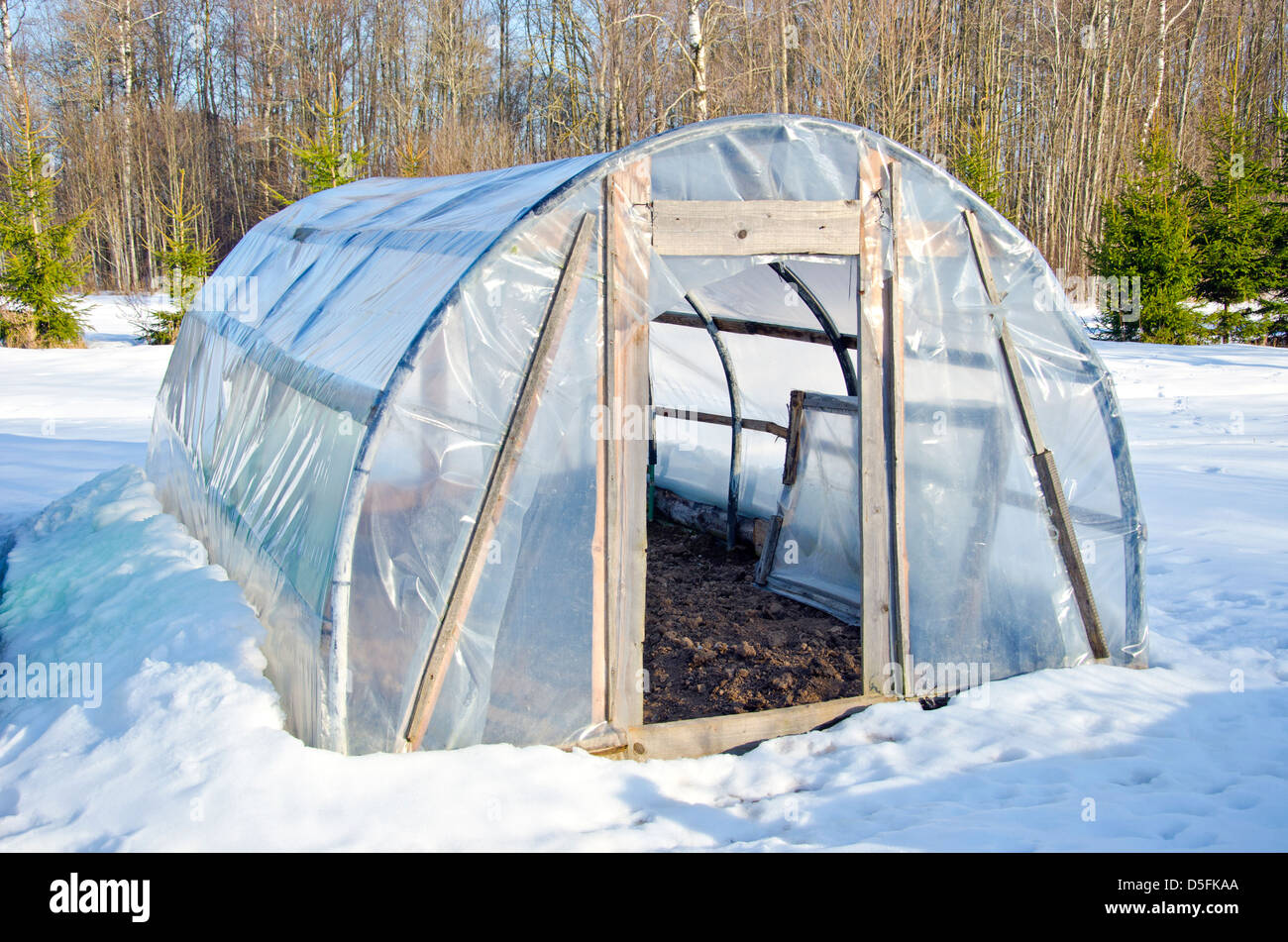 primitive handmade polythene greenhouse for vegetable  in winter time on snow Stock Photo