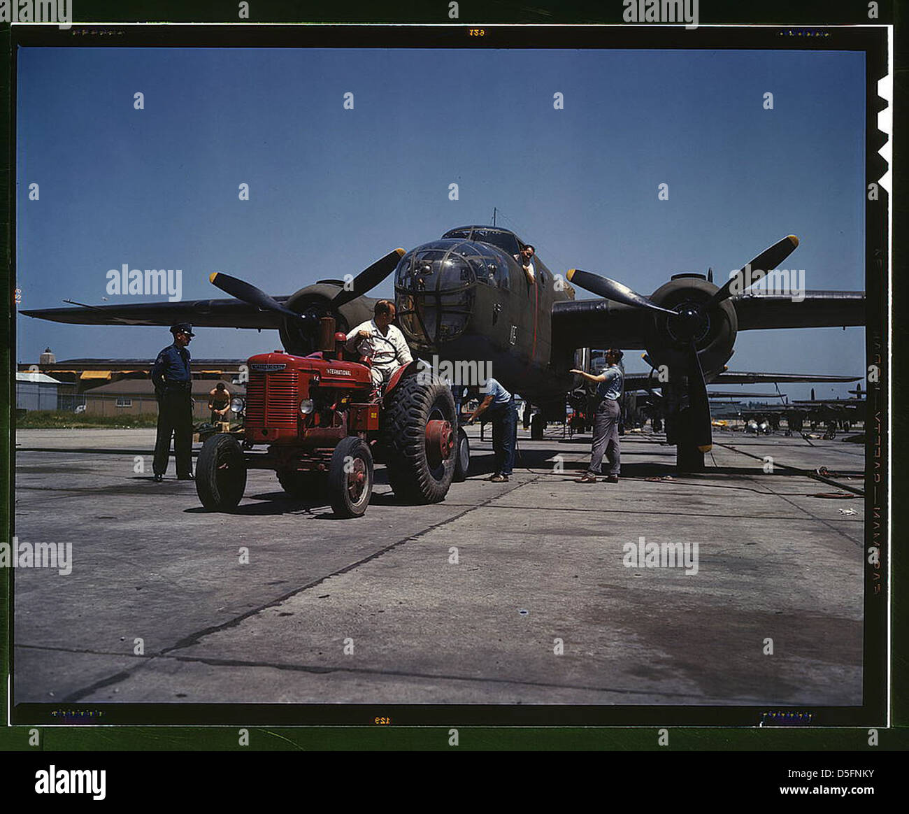 B-25 bomber planes at the North American Aviation, Incorporated being hauled along an outdoor assembly line with an 'International' tractor, Kansas City, Kansas (LOC) Stock Photo