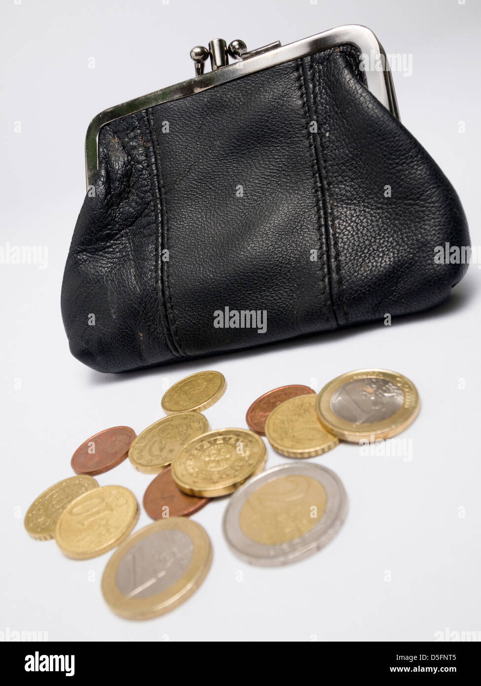 Old leather coin purse and Euro coins isolated on white background Stock Photo