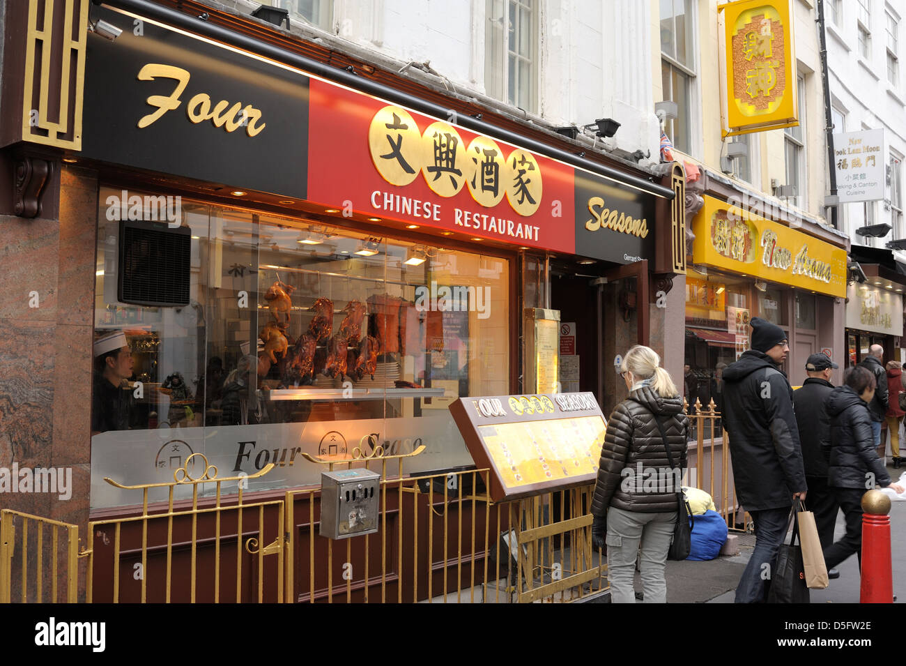 A passer by looking at the outside menu at a chinese restaurant in London's china town. Stock Photo