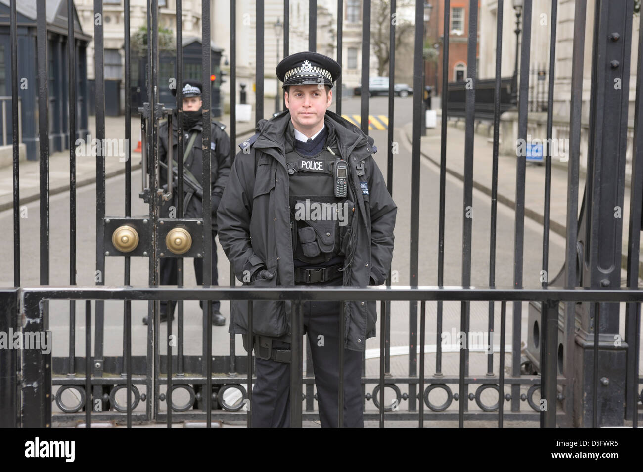 Armed police standing guard at the gates on the end of downing street  london security guards Stock Photo - Alamy