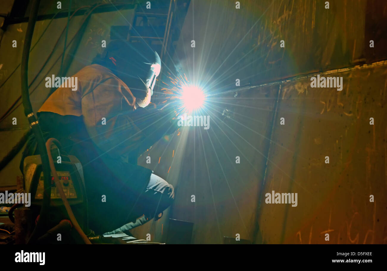 welding with mig-mag method inside of shipyard Stock Photo